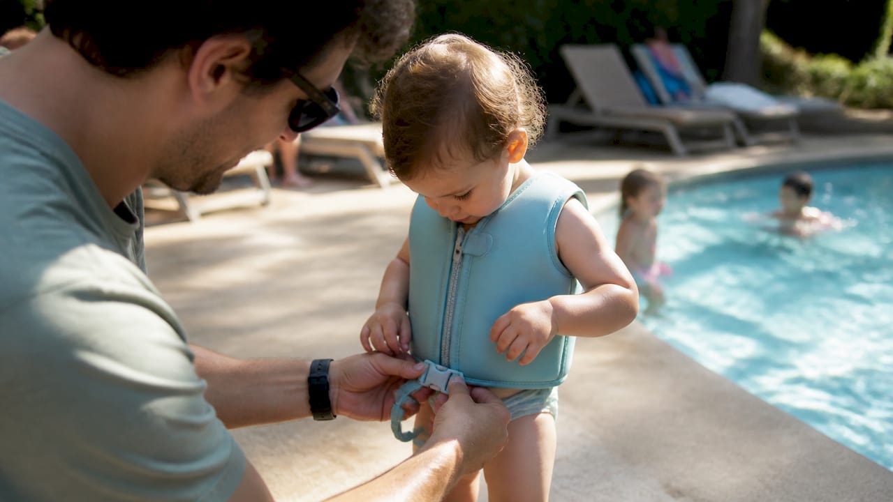 Kind trägt Schwimmweste am Pool